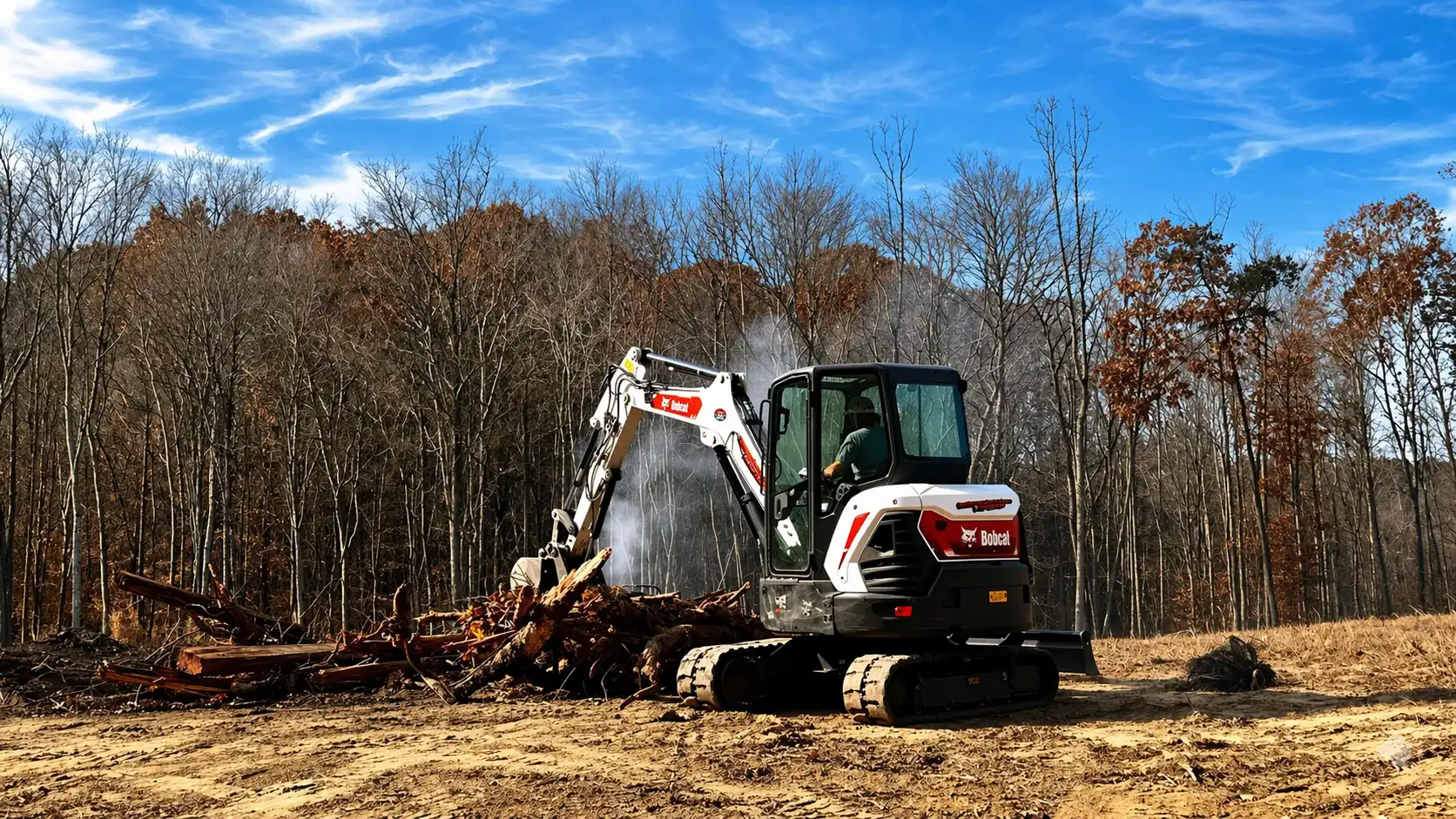 Excavator clearing logs in woodland clearing